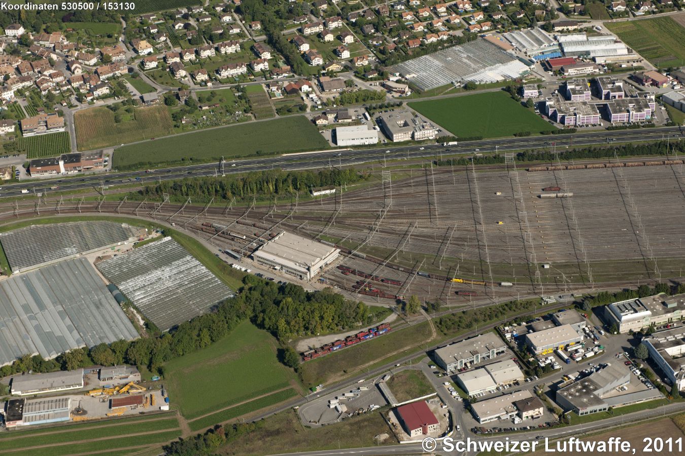 Rangierbahnhof Lonay in Ecublens (Position 2'530'509.56, 1'153'176.77). Am Bahnhof entlang führt die Autobahn A1. Links im Bild: Treibhäuser Lonay-Préverenges (Position 2'529'805.57, 1'152'800.16)